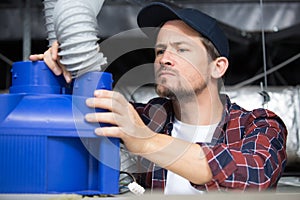man working on ceiling pipes