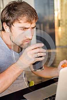 Man working at the computer and eating fast food. Unhealthy Life