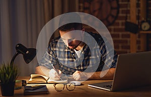 Man working on computer at home at night in dark