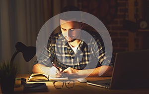 Man working on computer at home at night in dark