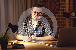 Man working on computer at home at night in dark