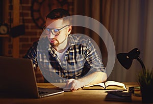 Man working on computer at home at night in dark