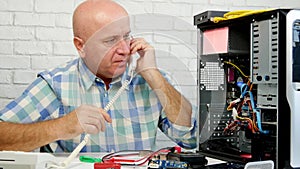 Man working in computer maintenance talk to telephone and gesticulate