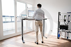 Man Working On Computer At Standing Desk