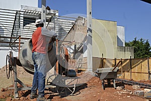 Man, construction worker using cement mixer, Brazil, south America , panoramic photo,