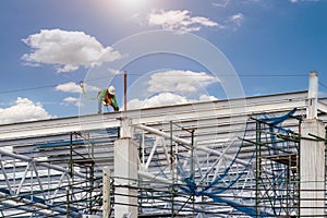 Man working on construction site with scaffold and building with sky background,scaffolding for construction factory