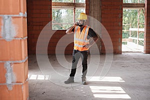 Man Working In Construction Site Smiling And Using Smartphone