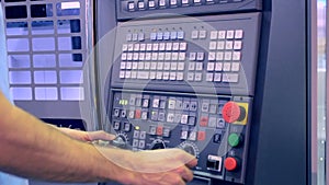 Man working on the control panel works with an industrial machine at the factory