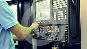 Man working on the control panel works with an industrial machine at the factory