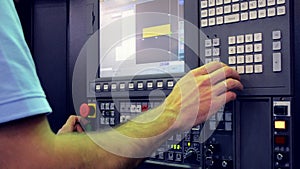 Man working on the control panel works with an industrial machine at the factory