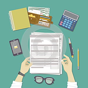 Man working with documents. Human hands hold the accounts, payroll, tax form. Workplace with papers, blanks, forms, phone. photo