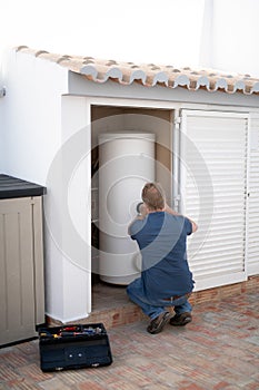 Man working on a domestic hot water tank