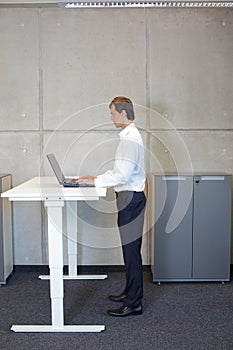 Man working at electrically controlled height adjustment table