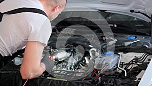 A man is working on the engine of a car