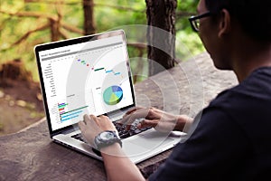 Man working with excel project dashboard on laptop / computer