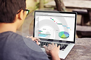 Man working with excel project dashboard on laptop / computer