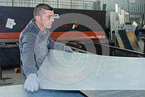 Man working at factory manufacturing tempered clear float glass