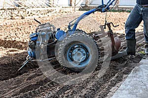 A man working in the field. A man plows the land with motor cultivator