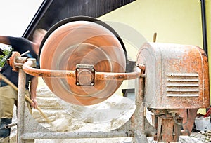 Man working with front of concrete cement mixer at construction