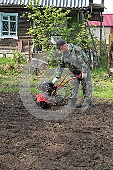 Man working in the garden preparing ground cultivator