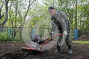 Man working in the garden preparing ground cultivator