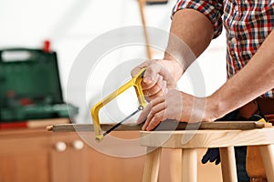 Man working with hand saw indoors. Home repair