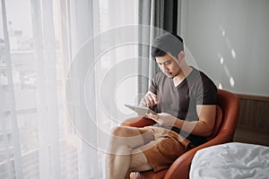 Man working with his digital tablet in the hotel in concept of workation.