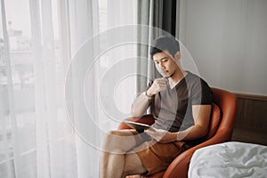 Man working with his digital tablet in the hotel in concept of workation.