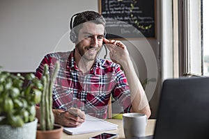 Man working from home in conference call with colleagues using headset