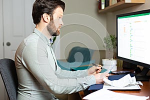 Man working from home on desktop computer with paperwork. HD 24FPS.