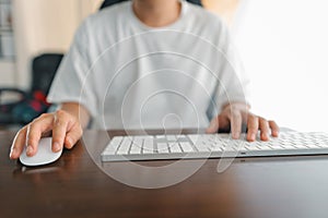 Man working at home, hands pressing computer keyboard, working at home