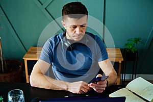 Bored man playing smartphone while working at home office