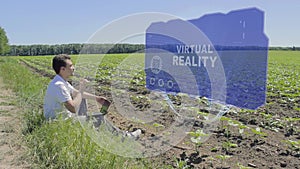 Man is working on HUD holographic display with text Virtual Reality on the edge of the field