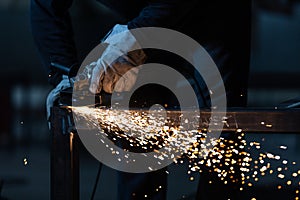 Man working on iron with grinder