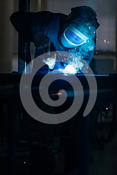 Man working on iron with grinder.