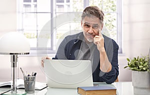 Man working with laptop computer in home office