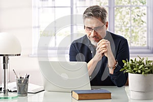 Man working with laptop computer in home office