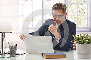 Man working with laptop computer in home office