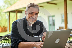 Man working with laptop computer at home outdoor in garden