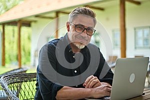 Man working with laptop computer at home outdoor in garden