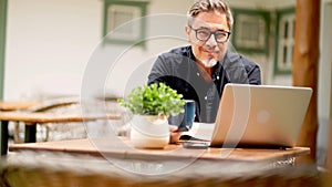 Man working with laptop computer at home outdoor on terrace