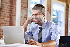 Man Working At Laptop In Contemporary Office