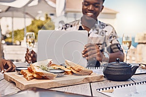 Man working on laptop eating lunch at restaurant, business meeting with friends and planning collaboration with food at