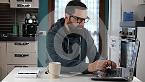 Man working on laptop from home angry banging fists on the table.