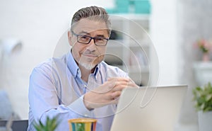 Man working with laptop in home office sitting at desk