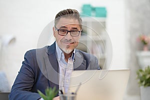 Man working with laptop in home office sitting at desk