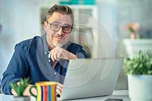 Man working with laptop in home office sitting at desk