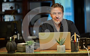 Man working with laptop in home office sitting at desk