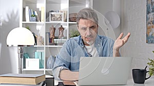 Man working with laptop at home office video call