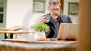 Man working with laptop at home outdoor on terrace